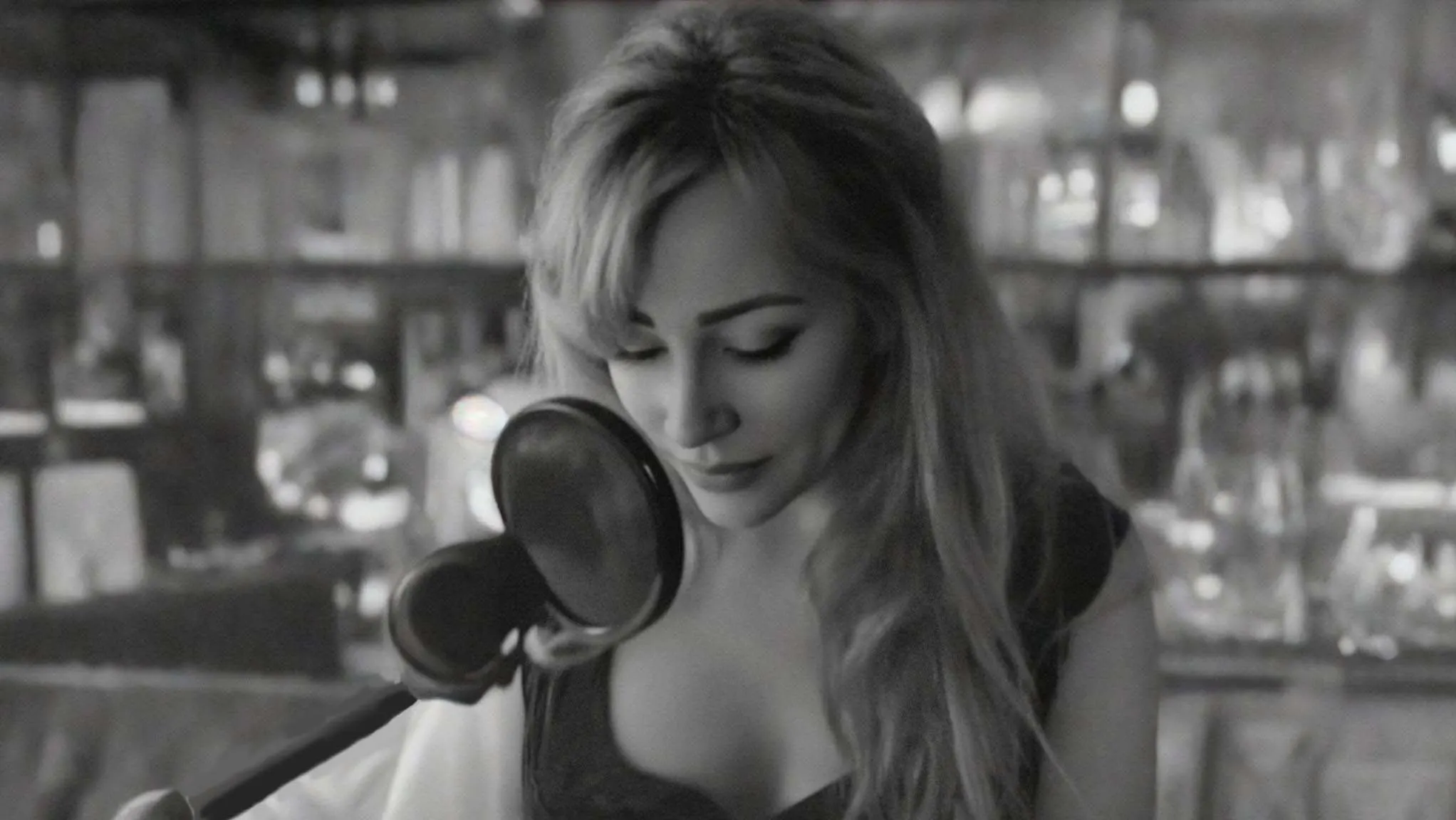 Black and white photograph of Gloria May Byron singing with her eyes closed at a microphone