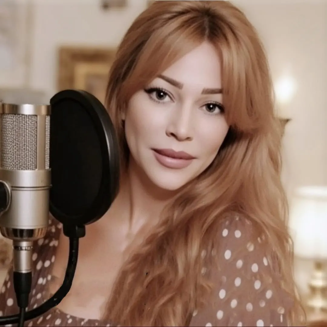 Gloria May Byron smiling at a studio microphone