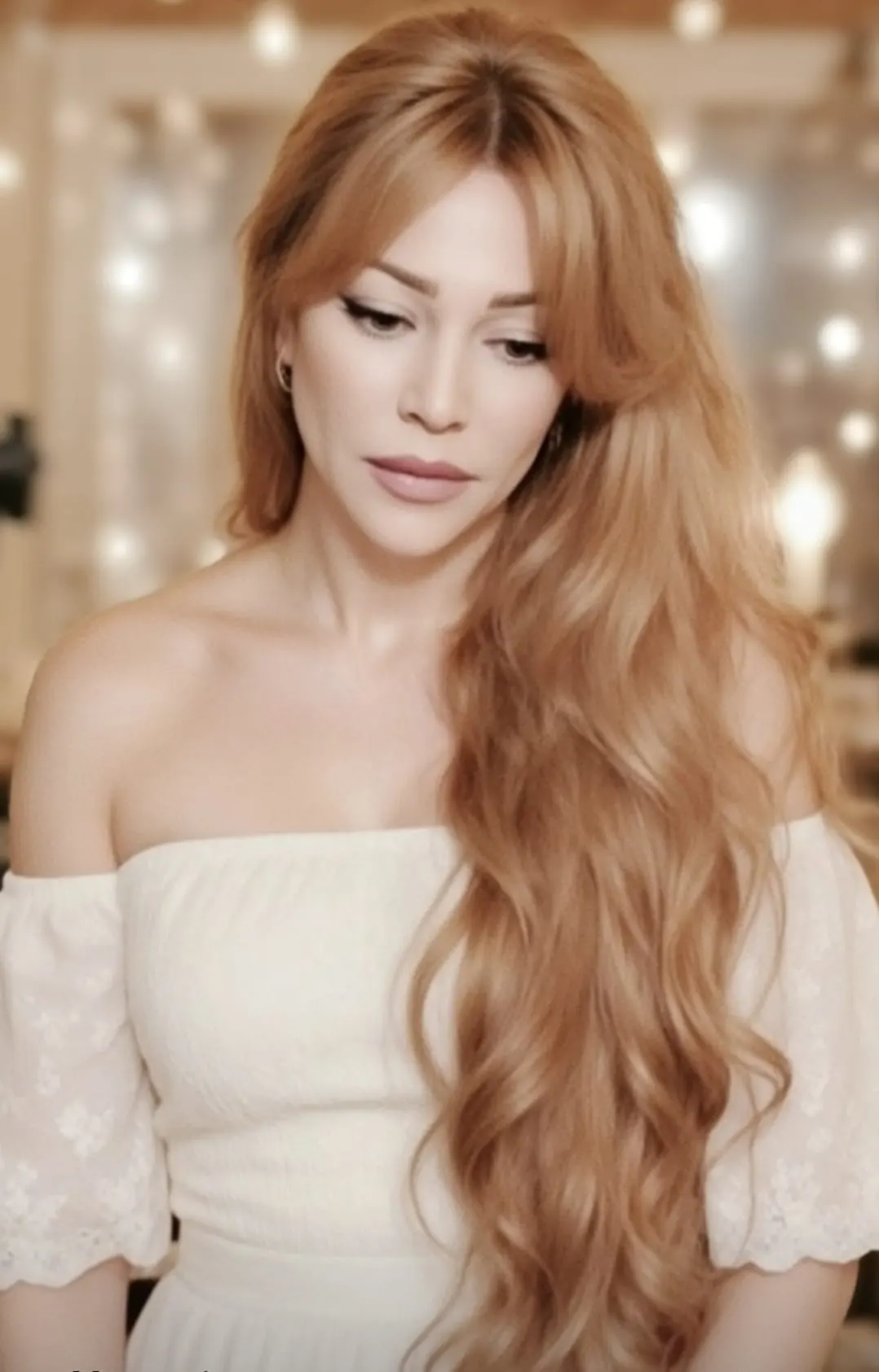 Gloria May Byron in a white off-shoulder top, long honey hair
