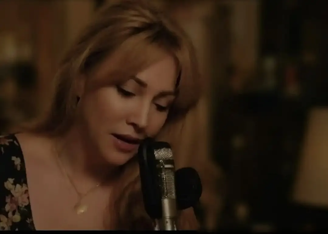 Gloria May Byron singing at a candlelit microphone